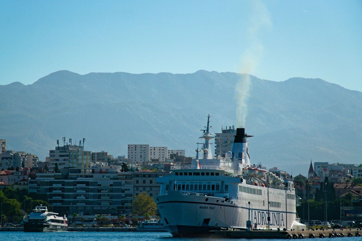 A Jadrolinija car ferry in Split harbour, with the city and the mountains behind